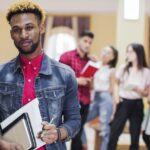 young black man posing with books